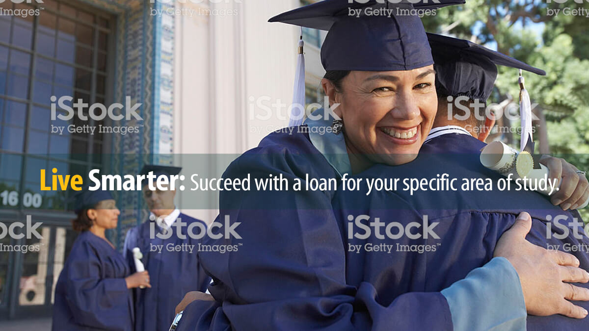 Graduate college students in caps and gowns congratulate each other after graduation ceremony